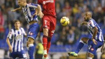 El centrocampista del Getafe Ángel Lafita salta a por un balón con el centrocampista argentino del Deportivo Luis Fariña, ante su compañero, el defensa brasileño Sidnei Rechel da Silva (d), durante el partido de la décima jornada de la Liga de Primera División que se juega hoy en el estadio de Riazor, en A Coruña.