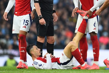 Un compañero ayuda a Gabriel Martinelli, jugador del Arsenal, a estirar durante el partido ante el Manchester City.