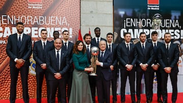 La presidenta de la Comunidad de Madrid, Isabel Díaz Ayuso (c), sostiene el trofeo de Copa del Rey de baloncesto junto al presidente del Real Madrid Florentino Fernández (d) y el entrenador del equipo de baloncesto, Chus Mateo (i), y jugadores durante la recepción celebrada en la Real Casa de Correos en Madrid, sede del gobierno regional, con motivo de su victoria en la Copa del Rey, este lunes.