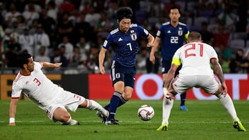 Iran&#039;s defender Ehsan Haji Safi (L) attempts a tackle on Japan&#039;s midfielder Gaku Shibasaki (C) during the 2019 AFC Asian Cup semi-final football match between Iran and Japan at the Hazza Bin Zayed Stadium in Abu Dhabi on January 28, 2019. (Photo