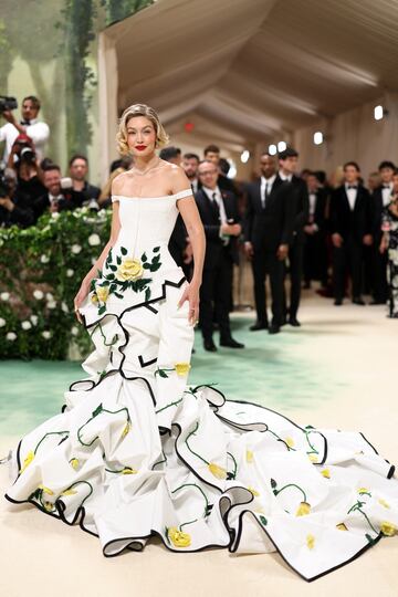 La modelo, Gigi Hadid, posa con un vestido blanco y flores amarillas del diseñador Thom Browne.