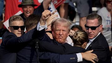 REUTERS PICTURES 40th ANNIVERSARY COLLECTION: Republican presidential candidate and former U.S. President Donald Trump is assisted by the Secret Service after gunfire rang out during a campaign rally at the Butler Farm Show in Butler, Pennsylvania, U.S., July 13, 2024. REUTERS/Brendan McDermid SEARCH "REUTERS PICTURES 40th ANNIVERSARY COLLECTION" FOR THIS PACKAGE