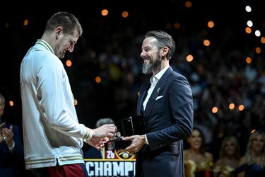 Nikola Jokic recibe su anillo de Josh Kroenke, presidente del equipo de Colorado.