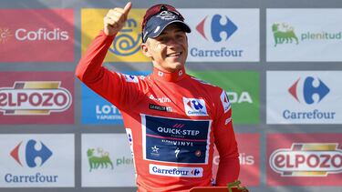 Team Quick Step's Belgian rider Remco Evenepoel celebrates on the podium wearing the overall leader's red jersey after the 9th stage of the 2022 La Vuelta cycling tour of Spain, a 171.4 km race from Villaviciosa to Les Praeres, Nava, on August 28, 2022. (Photo by ANDER GILLENEA / AFP)