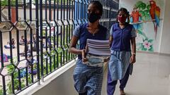 Students collect text books before attending a tele-learning class at their home, an initiative set up by the Department of School Education to allow students from class 2 to 10 to continue with their curriculums as schools remain closed as a preventive m