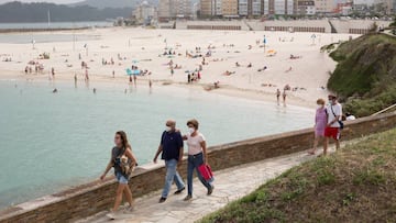 Ciudadanos pasean junto a la playa de Rapadoira de Foz, en la comarca gallega de A Mari&ntilde;a (Lugo), que estar&aacute; cerrada durante cinco d&iacute;as tras declararse un brote de coronavirus que afecta a m&aacute;s de un centenar de personas, a 5 de