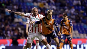 MEX1541. PUEBLA (MÉXICO), 16/08/2022.- Jordi Cortizo (d) del Puebla disputa hoy el balón con Juan Segovia del Necaxa, durante un partido por la jornada 9 del torneo Apertura 2022 de la Liga MX, en el estadio Cuauhtémoc en Puebla (México). EFE/Hilda Ríos
