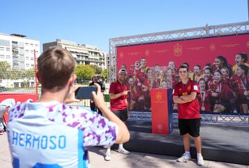 Córdoba se ha volcado con la Selección española y las muestras de apoyo a las campeonas del mundo se han visto por toda la ciudad. Sobre estas líneas, un aficionado con una camiseta de Jenni Hermoso hace una foto a otros dos seguidores delante de una lona con la imagen de las jugadoras y del trofeo de la Copa Mundial de fútbol femenino.