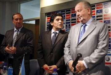 En 2008, cumple uno de sus anhelos: Es contratado y presentado como director técnico de la selección argentina, tras la renuncia de Alfio Basile. Su debut fue contra Esocia, en duelo ganado por la albiceleste. En la imagen, Maradona aparece junto a Carlos Bilardo (izquierda), y el fallecido Julio Grondona.