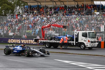 El Williams de Alexander Albon pasa junto a su compa?ero accidentado, Carlos Sainz mientras es retirado por los comisarios de carrera.