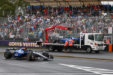 El Williams de Alexander Albon pasa junto a su compañero accidentado, Carlos Sainz mientras es retirado por los comisarios de carrera.