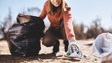 Close-up of eco-friendly woman collecting the trash in nature.