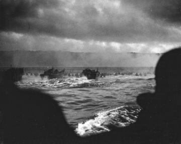 Espectacular fotografía del Día D, tomada desde una barcaza de desembarco por un fotógrafo de combate de la Guardia Costera, muestra a los soldados hasta la cintura mientras se lanzan hacia el ataque.