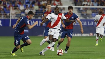 Imbula conduce el bal&oacute;n ante jugadores del Huesca.