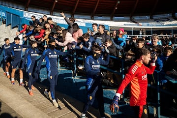 Los jugadores del Zaragoza chocan las cinco con los aficionados al salir al campo.