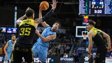 ANDORRA, 28/12/2024.- El pívot del Lenovo Tenerife Fran Guerra (i) defiende al base del MoraBanc Ferrán Bassas (c) durante el partido de la decimotercera jornada de la Liga Endesa disputado este sábado en el Poliesportiu d'Andorra. EFE/ Fernando Galindo