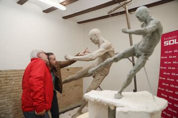 El artista Javi Molina explica a José Antonio Iniesta, padre de Andrés Iniesta, el proceso de creación de la escultura de su hijo en su taller de Valencia. 