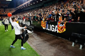 El capitán del Valencia Club de Fútbol, Gayá, lanza balones firmados a la grada de Mestalla.