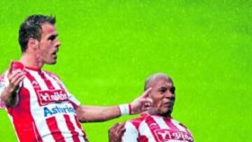 <b>DISFRUTANDO BAJO LA LLUVIA. </b>Mate Bilic y Gregory celebran el único tanto del encuentro bajo la intensa lluvia que cayó ayer sobre el césped de El Molinón.