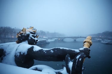 Vista de una estatua cubierta de nieve en el Puente Alexandre III en París mientras el clima invernal con nieve y temperaturas frías azota una parte del país.