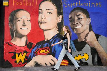 El artista callejero italiano Salvatore Benintende, conocido por el seudónimo de TVBOY, ha homenajeado a las flamantes campeonas de la Champions femenina con un gran mural en la Plaza de Joanic de Barcelona. En la obra de TVBOY Aitana Bonmatí es Wonder Woman, Alexia Putellas es Super Woman y Salma Paralluelo, Batgirl. 