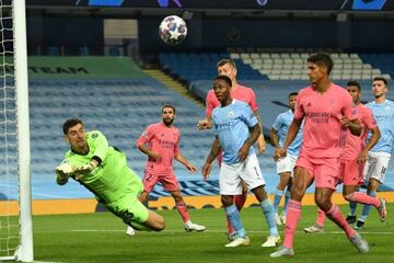 Thibaut Courtois (L) dives to make a save from a corner kick.