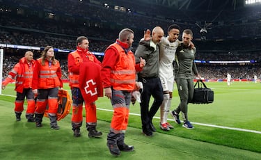 El jugador no puede apoyar la pierna izquierda y es ayudado por los médicos del Real Madrid a abandonar el terreno de juego.