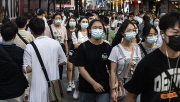 WUHAN, CHINA - OCTOBER 3: People wear masks while walking along a street on October 3, 2021 in Wuhan, Hubei province, China. A yellow high temperature warning was issued locally while the maximum temperature reached 98.6 Fahrenheit. China is celebrating t