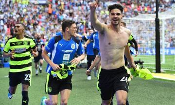 Huddersfield Town's German defender Christopher Schindler (R) celebrates with teammates after he scores the final winning penalty in the shoot-out during the English Championship play-off final football match between Huddersfield Town and Reading