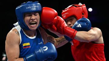 Colombia's Yeni Marcela Arias Castaneda (in blue) takes a punch from South Korea's Im Ae-ji in the women's 54kg quarter-final boxing match during the Paris 2024 Olympic Games at the North Paris Arena, in Villepinte on August 1, 2024. (Photo by MOHD RASFAN / AFP)