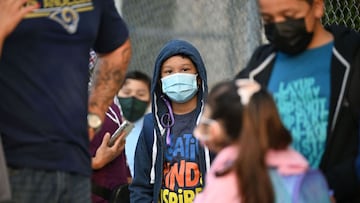 Students and parents wearing face coverings wait in line for the first day of the school year at Grant Elementary School in Los Angeles, California on August 16, 2021.