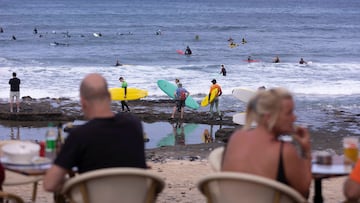 GRAFCAN8760. ARONA (TENERIFE), 08/04/2023.- Numerosos turistas disfrutan del buen tiempo este sábado en la zona turística del municipio de Arona, al sur de la isla de Tenerife. En la imagen, numerosos surferos cogen olas en la zona de El Conquistador. EFE/ Miguel Barreto