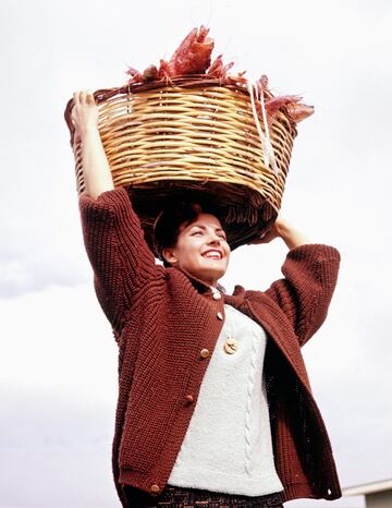 Carmen Sevilla con una cesta de marisco en la cabeza en su casa de San Juan, Alicante.