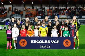 Once inicial del Valencia junto a once niñas de sendos clubes de Escoles VCF de los municipios gravemente dañados por la DANA.