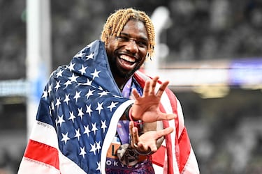El atleta estadounidense Noah Lyles, tercero en la clasificación, celebra con la bandera de su país tras la final masculina de los 100 metros durante el Campeonato Mundial de Atletismo en Tokio.