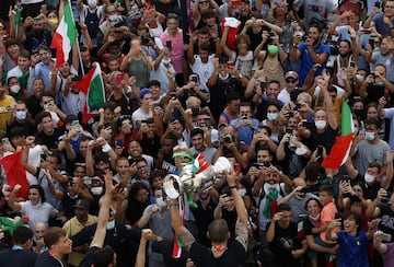Los aficionados saludando a los jugadores mientras Bonucci sostiene la copa en ato.