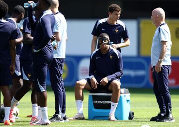 El defensor francés Benjamin Pavard (arriba) y el delantero francés Kylian Mbappé, con una máscara protectora, participan en una sesión de entrenamiento.