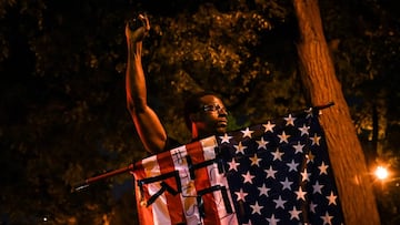 A demonstrator raises his fist as he holds an American flag during a protest against racial inequality in the aftermath of the death in Minneapolis police custody of George Floyd, in New York City, New York, U.S. June 9, 2020. Picture taken June 9, 2020. 