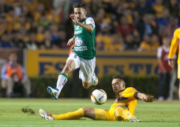 Anselmo Vendrechovski (R) of Tigres vies for the ball with Fernando Navarro (L) of Leon during their Mexican Apertura 2017 tournament football match at the Universitario stadium in Monterrey, Mexico on November 25, 2017. / AFP PHOTO / Julio Cesar AGUILAR