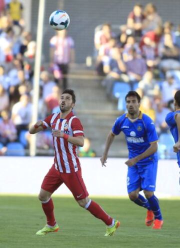 El delantero del Atlético de Madrid David Villa (i) intenta controlar el balón ante el centrocampista del Getafe Juan Rodríguez (d), en el partido de la trigésima tercera jornada de liga de Primera División disputado esta tarde en el Coliseo Alfonso Pérez de Getafe.