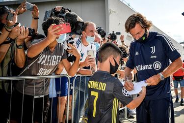 La Juventus de Andrea Pirlo echo a andar con las pruebas médicas a los jugadores para iniciar los entrenamientos de manera inmediata de cara a una temporada en la que se le volverá a exigir el asalto a la Champions. En la imagen, Pirlo firma autógrafos a la salida del centro médico juventino.