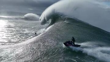 Un surfista en una de las olas gigantes del swell XL que rompió en Praia do Norte, Nazaré (Portugal) el 7 de noviembre del 2022, con un jet ski de Red Bull siguiéndole para el posterior rescate.