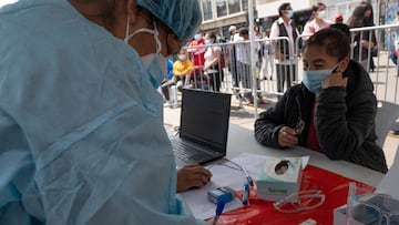 A woman waits to be swabed for COVID-19 at a makeshift health center on a street in downtown Lima on January 5, 2022, hours after the Government reported the country is officially facing a third wave of COVID-19 due to the increase of infections after Christmas and New Year festivities. - &quot;During the month of December, COVID-19 cases doubled in Lima and increased by more than 50% nationwide,&quot; said Health Minister Hernando Cevallos at a press conference announcing the measure, also announcing he will propose to the Council of Ministers the adoption of new restrictions. Peru registers 309 cases of the highly contagious omicron variant. (Photo by Cris BOURONCLE / AFP)