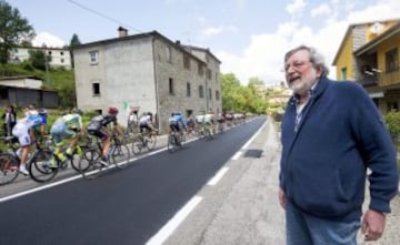 El cantante y compositor italiano Francesco Guccini observa al pelot¨®n durante la d¨¦cima etapa del Giro de Italia.