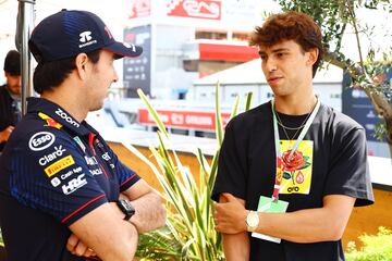 El piloto mexicano Sergio Perez charla con el futbolista portugués João Félix en el paddock.