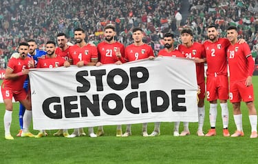 Los jugadores palestinos con una pancarta donde se puede leer 'Stop Genocide'.