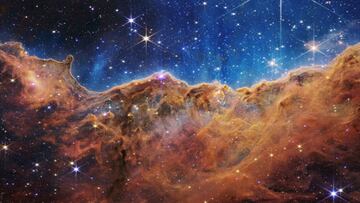 IN SPACE - JULY 12: In this handout photo provided by NASA, a landscape of mountains and valleys speckled with glittering stars is actually the edge of a nearby, young, star-forming region called NGC 3324 in the Carina Nebula, on July 12, 2022 in space. Captured in infrared light by NASA's new James Webb Space Telescope, this image reveals for the first time previously invisible areas of star birth.  (Photo by NASA, ESA, CSA, and STScI via Getty Images)