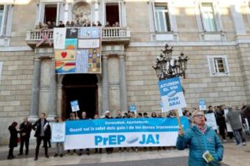 Miembros de la plataforma "Gais contra el VIH", durante la protesta que dicha asociación ha protagonizado hoy en la plaza de Sant Jaume de Barcelona, para pedir la implantación en la sanida pública de la PrEp, una medicación preventiva contra el VIH, durante el acto simultáneo de la Generalitat y el Ayuntamiento con motivo de la celebración del Día Mundial del Sida. EFE/Toni Albir