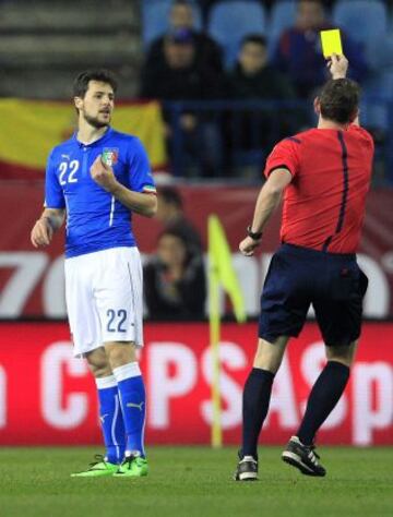 El árbitro ucraniano Yeivgen Aranovskyi muestra tarjeta amarilla al jugador italiano Destro.