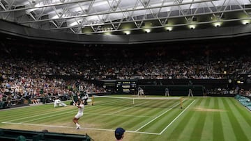 Imagen de la pista central de Wimbledon durante el encuentro de semifinales entre Rafa Nadal y Novak Djokovic en la pista central, con visibles calvas sobre la hierba.
